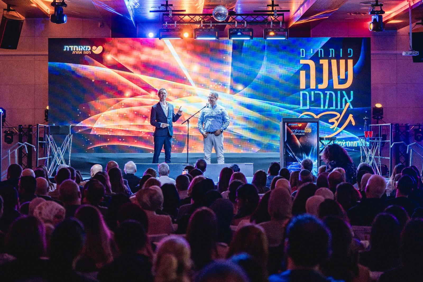 כנס חברה עם במה ומסך ענק מול קהל מלא